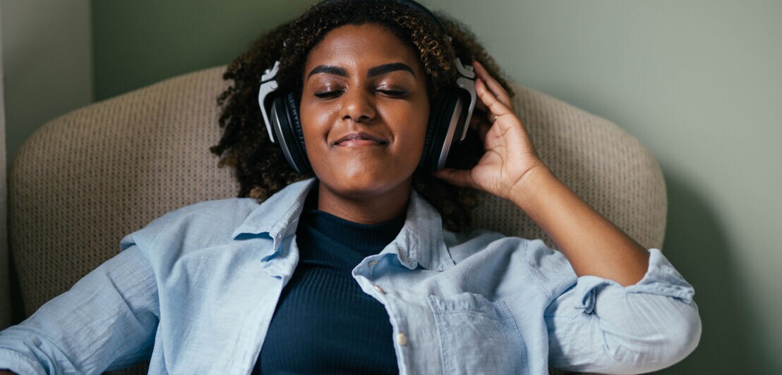 Eine Frau hört Musik mit geschlossenen Augen.