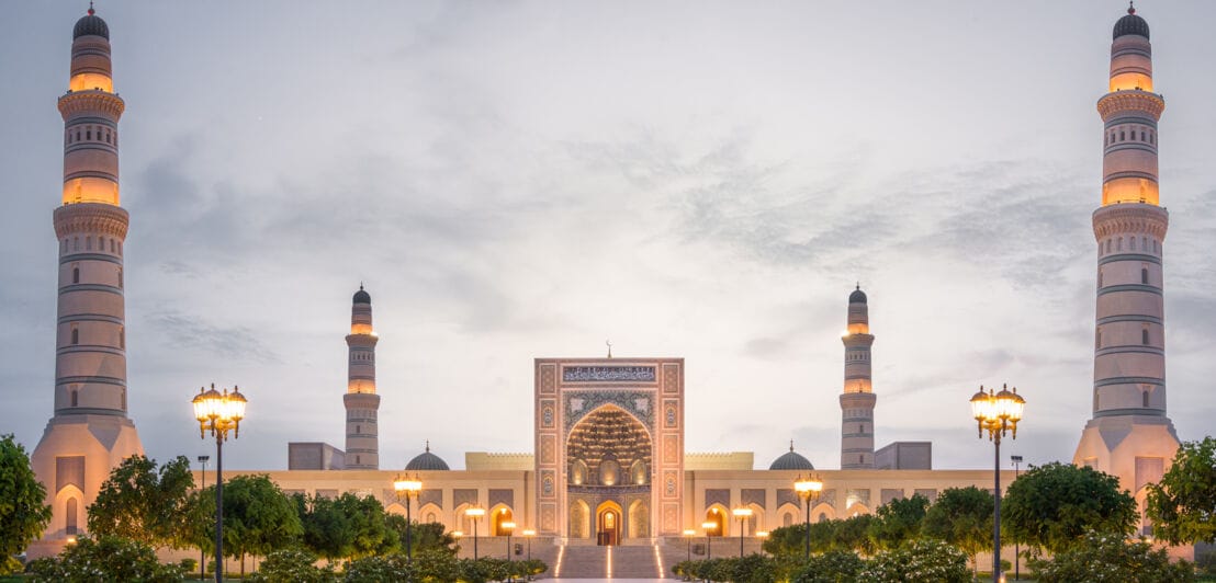 Große Moschee mit vier hohen Minaretten und einem verzierten Eingangstor bei Dämmerung