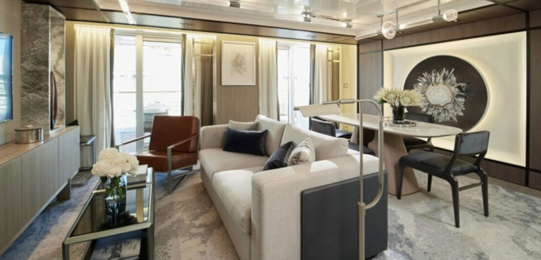 Helles Wohnzimmer einer luxuriösen Suite mit Balkon.