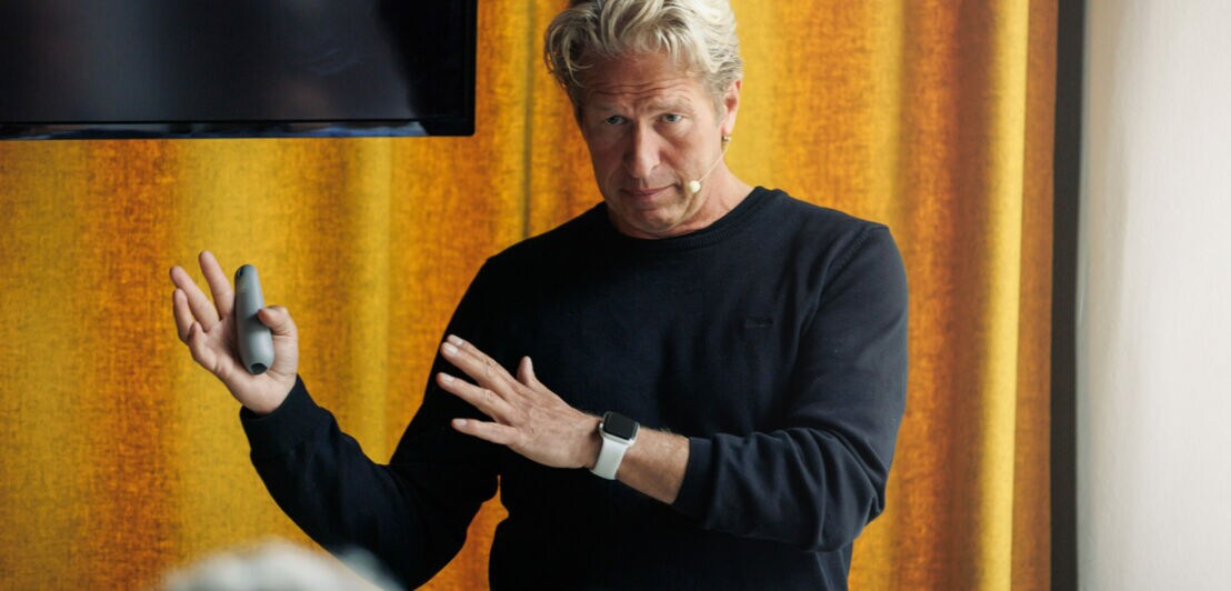 Oliver Leisse steht vor einer Gruppe von Menschen und hält einen Vortrag.