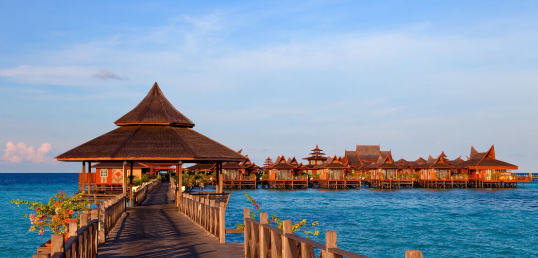 Holzsteg mit luxuriösen Holzbungalows auf dem Wasser.