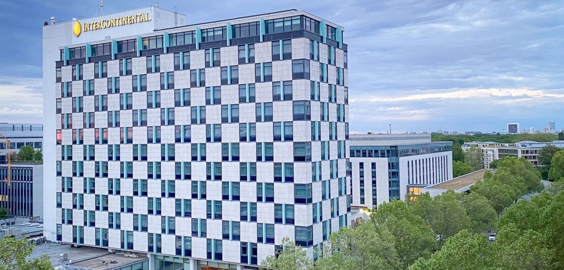 Außenansicht eines Hochhauses mit Schachbrettfassade und Intercontinental-Logotype in urbaner Umgebung.