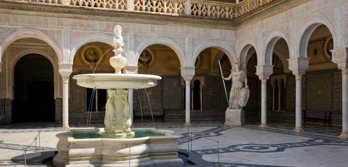 Innenhof der Casa de Pilatos mit zentralem Brunnen, verzierten Arkaden und Renaissance- sowie spanischen Mudéjar-Elementen.