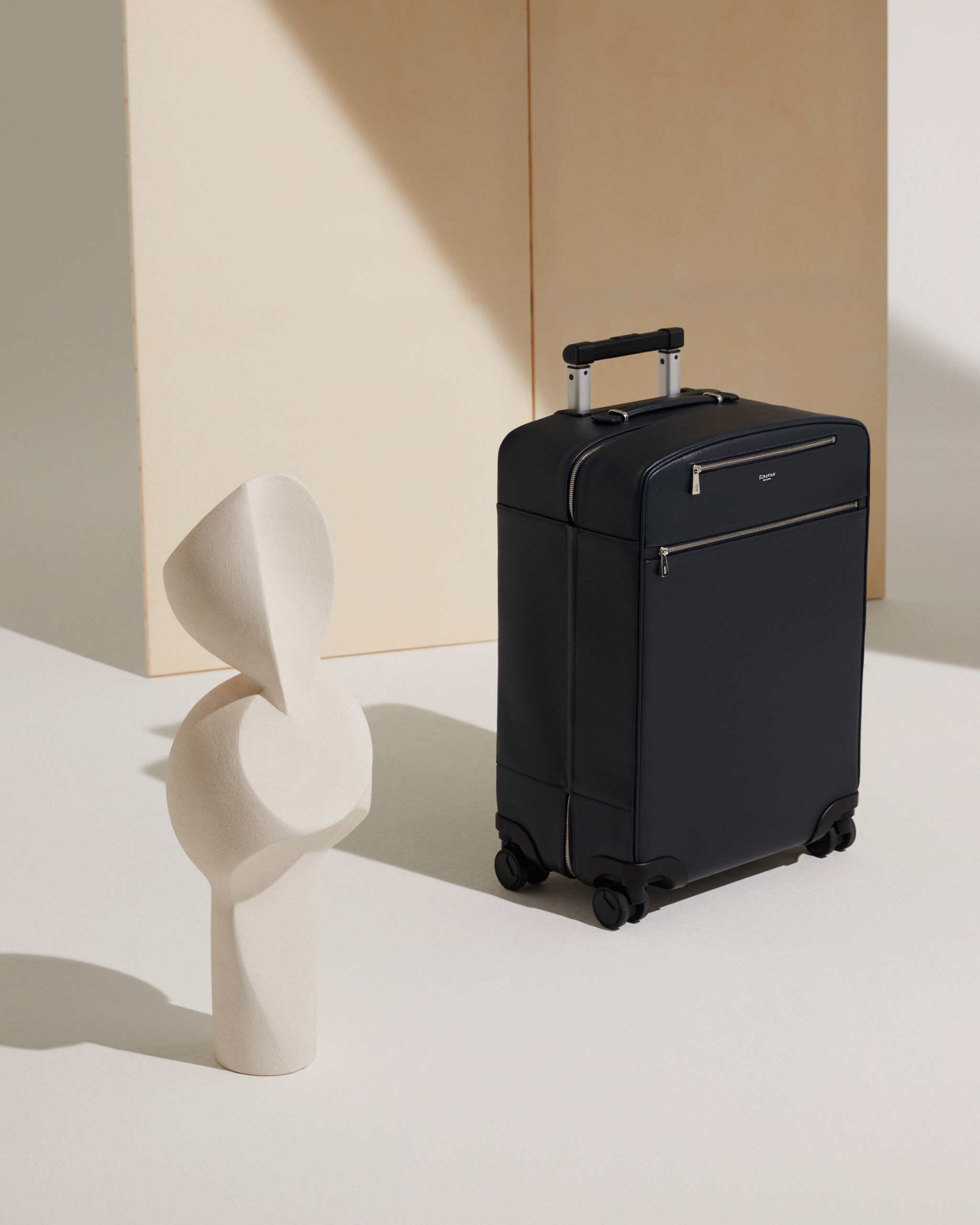 Ein schwarzer Koffer neben einer weißen Skulptur