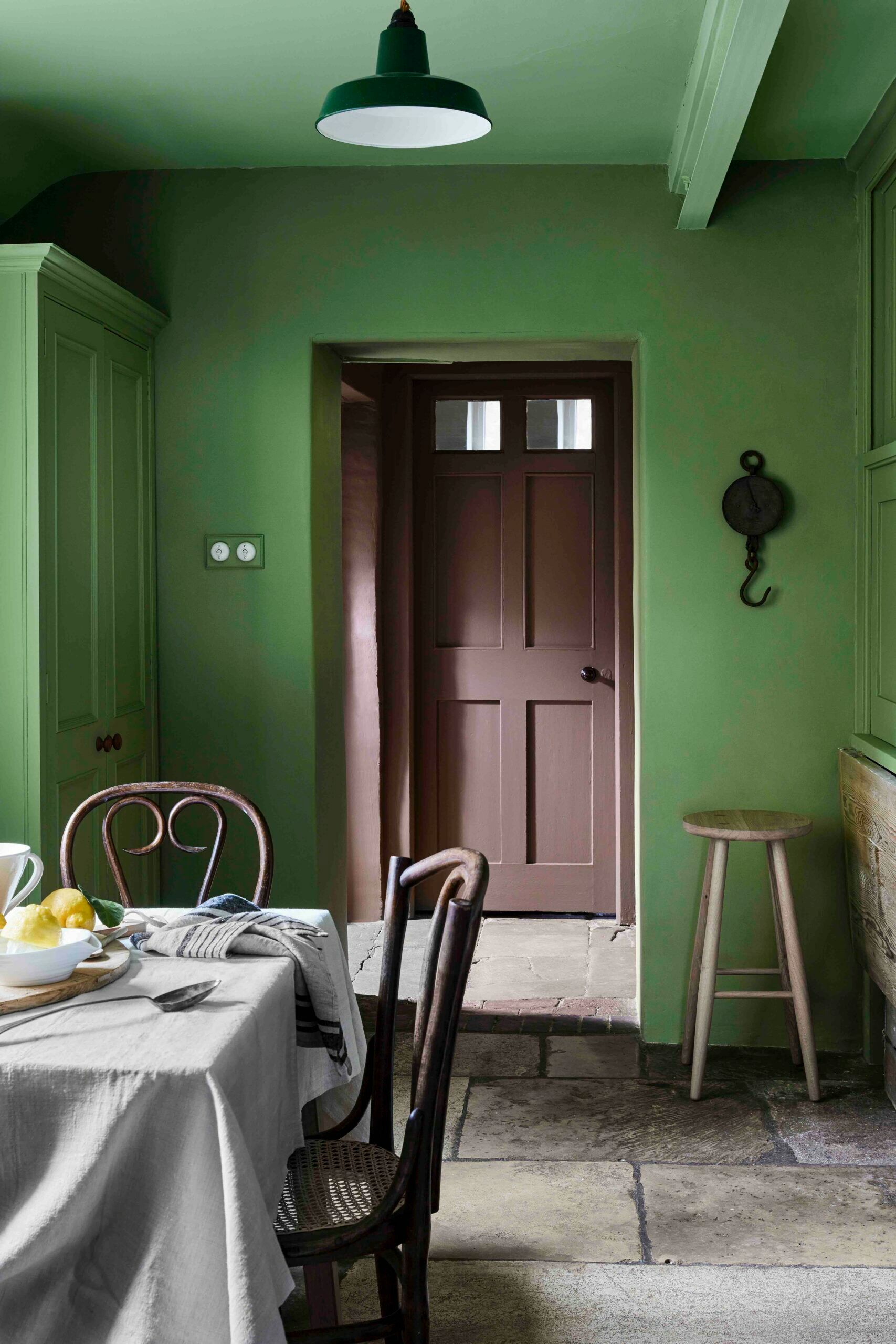 Eine eher ländliche Küche mit grünen Wänden und braunen Türen