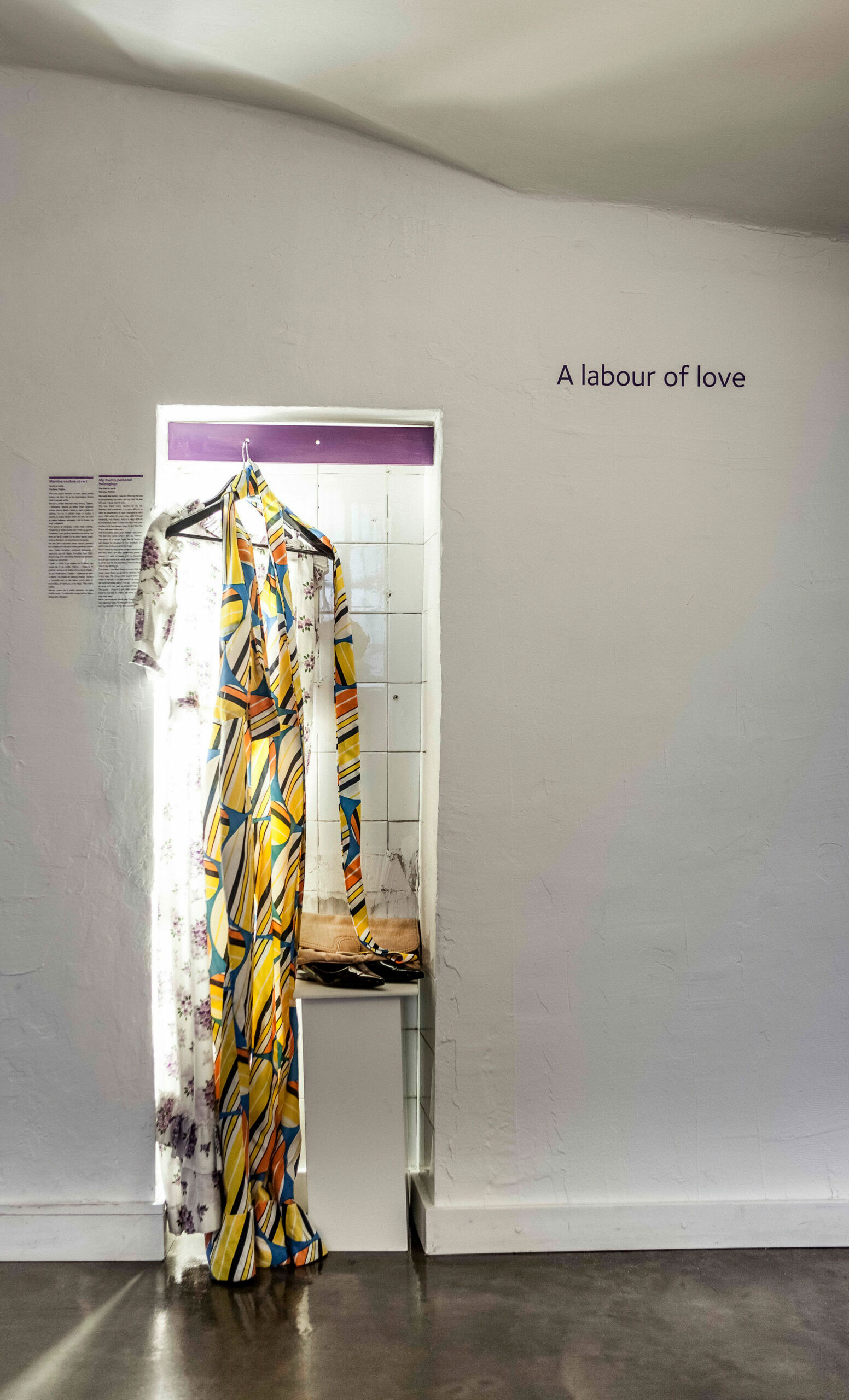Zwei gemusterte Kleider, welche aufgebügelt an einer lila Garderobe hängen