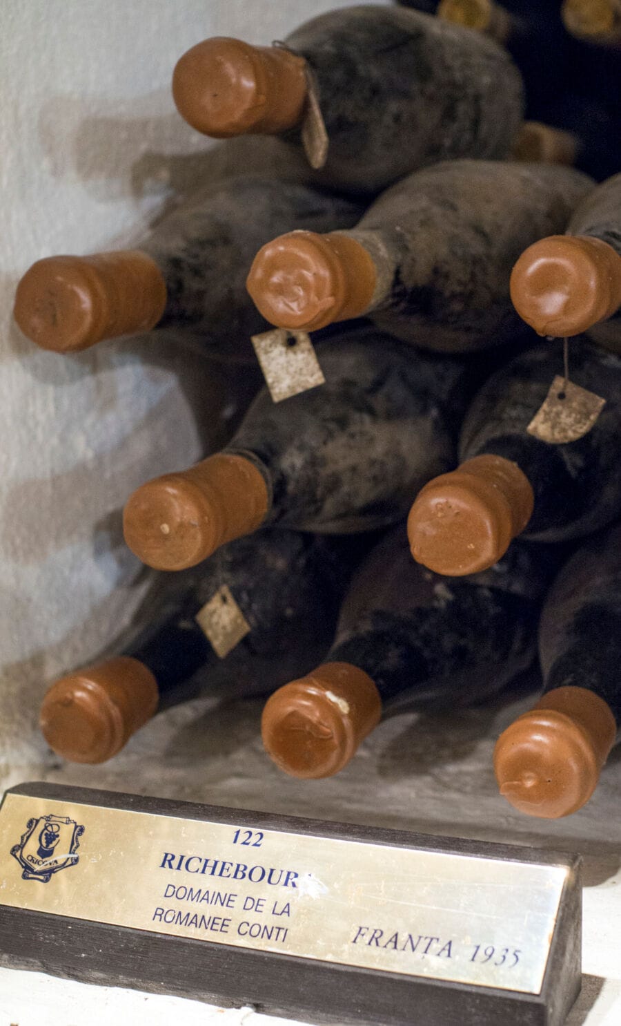 Gestapelte, verstaubte Rotweinflaschen aus dem Jahre 1935