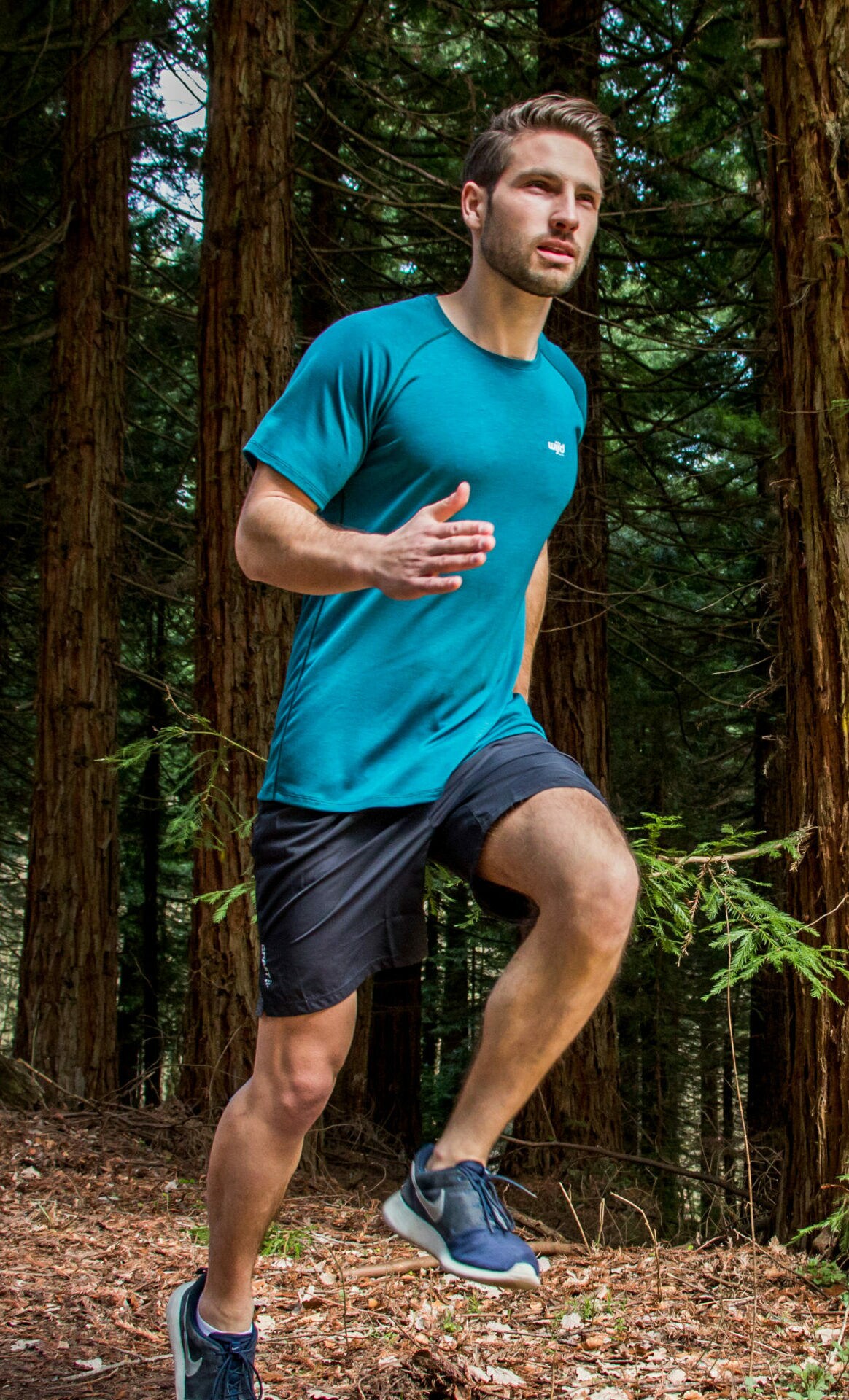 Mann joggt in Sportbekleidung durch einen Wald
