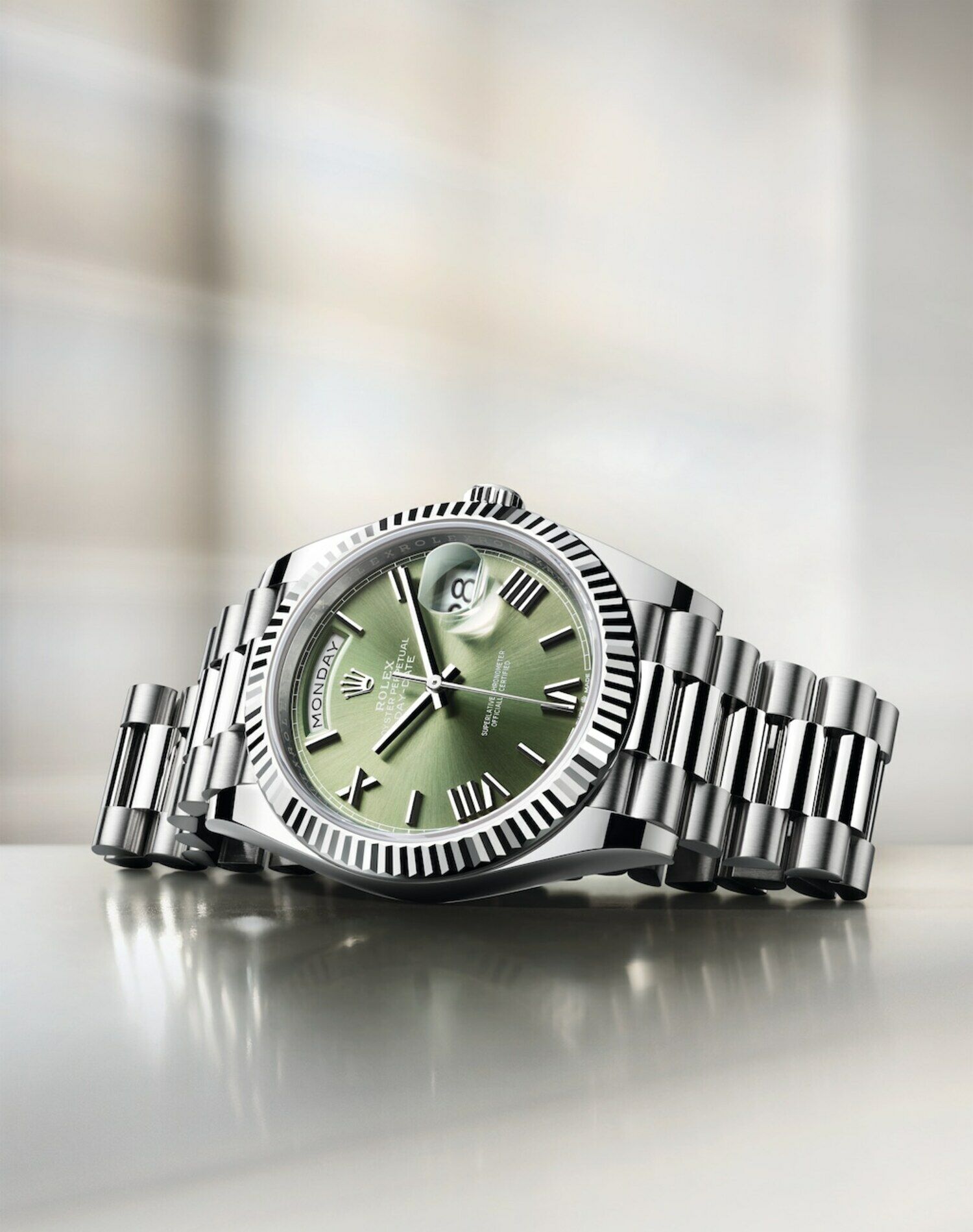 Eine silberfarbene Uhr mit olivgrünem Zifferblatt von Rolex