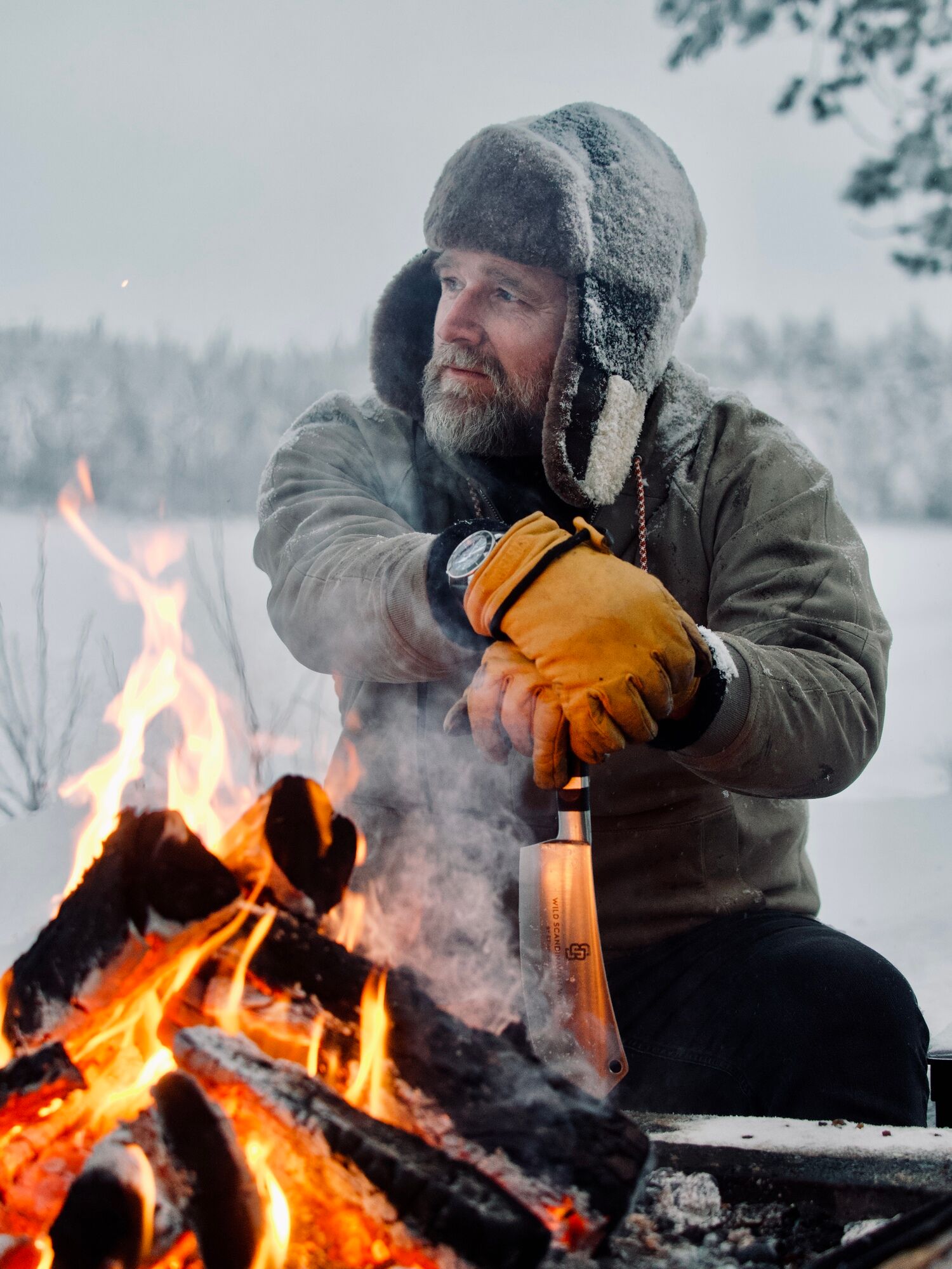 Brian Bojsen sitzt am Lagerfeuer im Schnee
