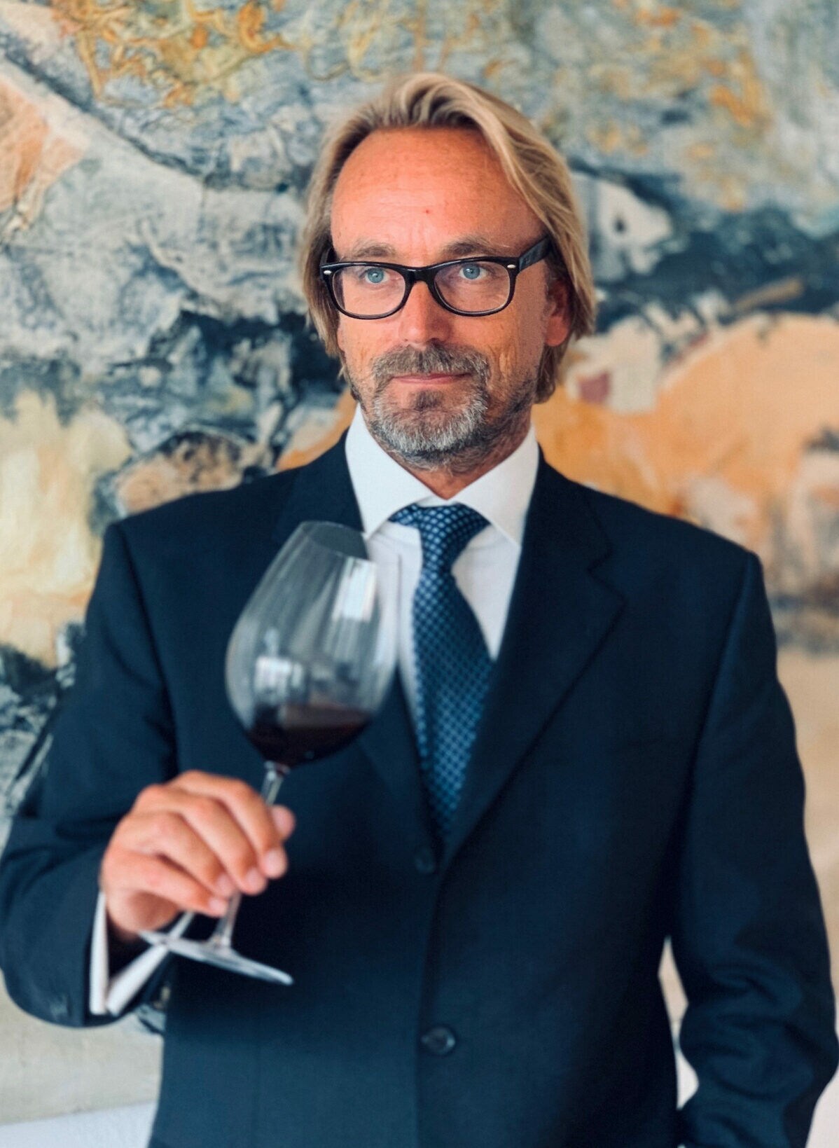 Porträt von Heiko Schimeczek mit einem Glas Wein in der Hand