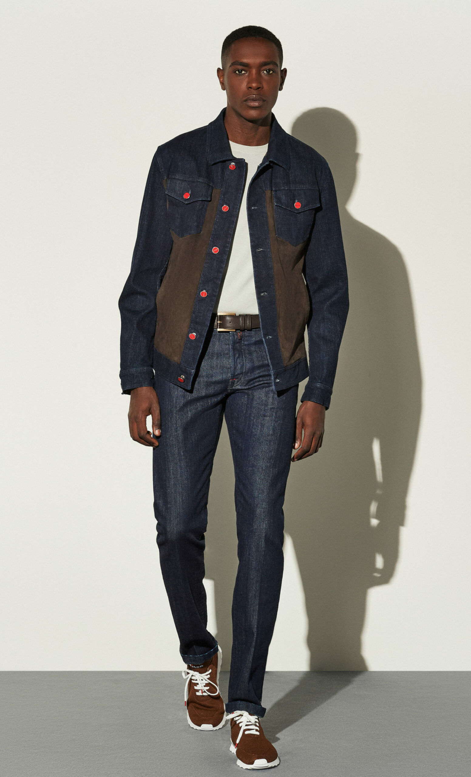 Model in Jeansjacke mit Ledereinsätzen und roten Knöpfen, Studioaufnahme