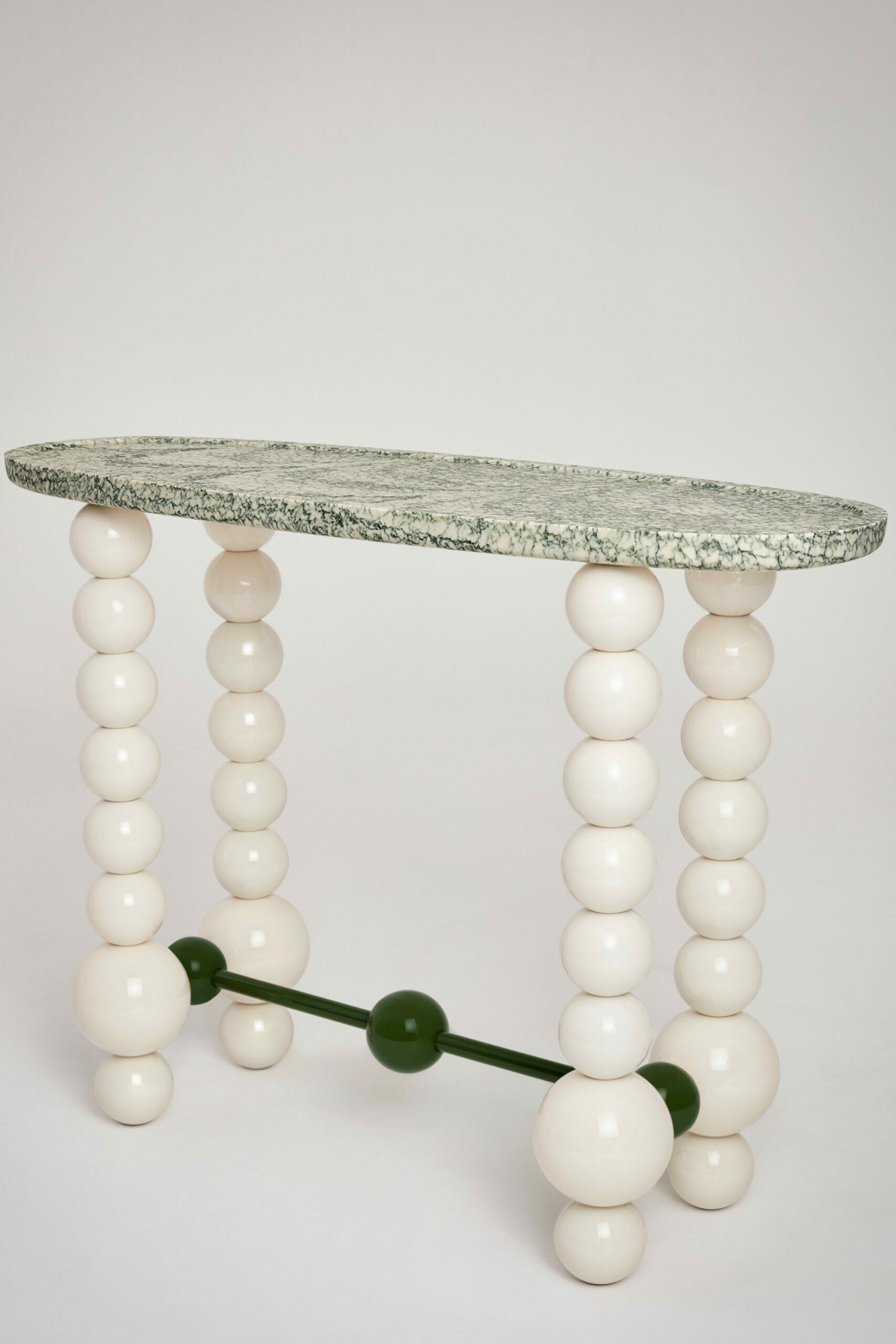 Ein Tisch aus Marmor, dessen vier weiße Beine wie dicke Perlen an Schnüren wirken
