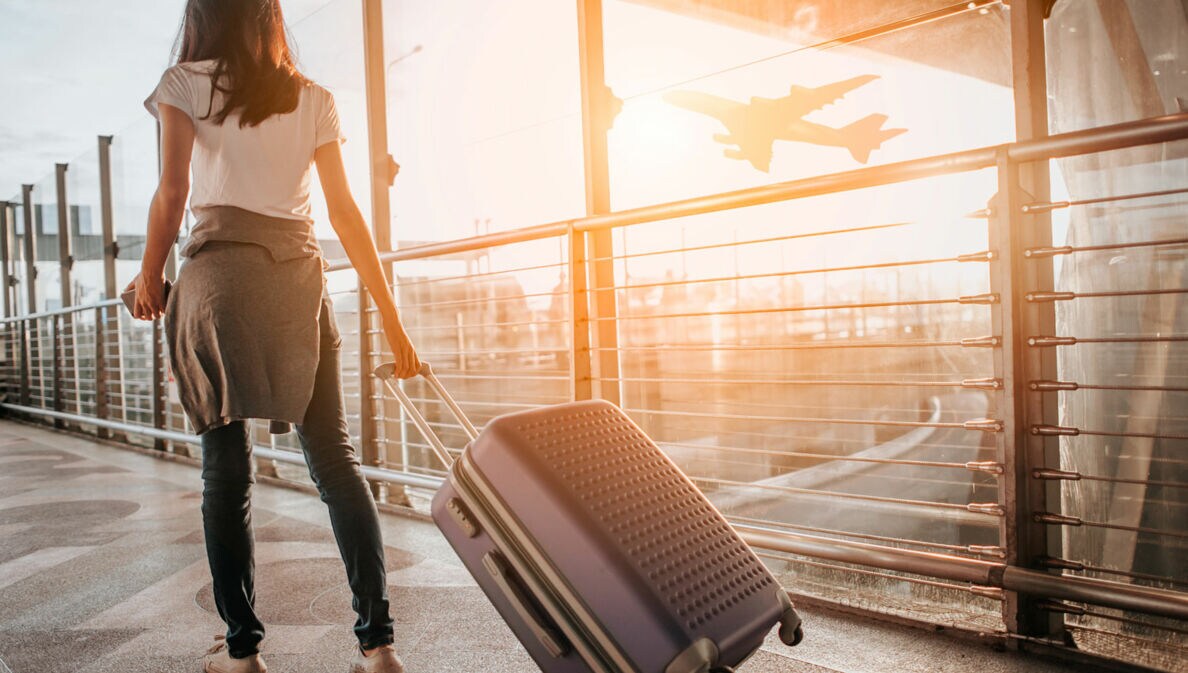 Frau zieht Koffer durch den Flughafen