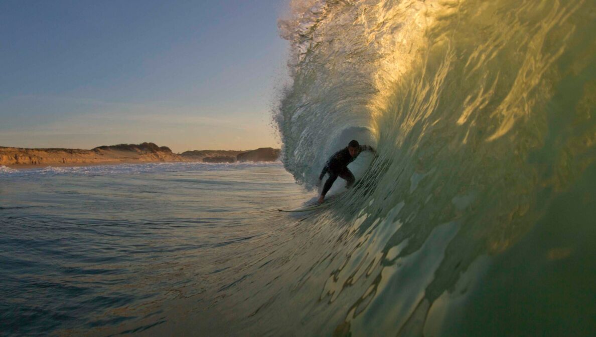 Surfer in einer sich brechenden Welle vor Hossegor in Frankreich