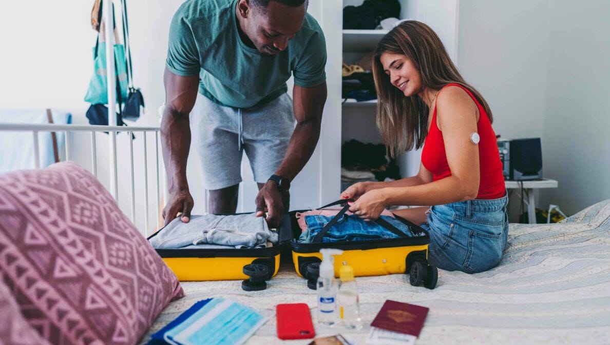 Ein Mann und eine Frau packen einen Koffer für eine Urlaubsreise.