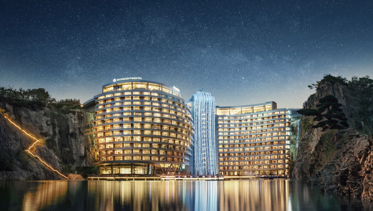 Blick auf das erleuchtete futuristische und zwischen steilen Felsen eines Steinbruchs gelegene InterContinental Shanghai Wonderland.