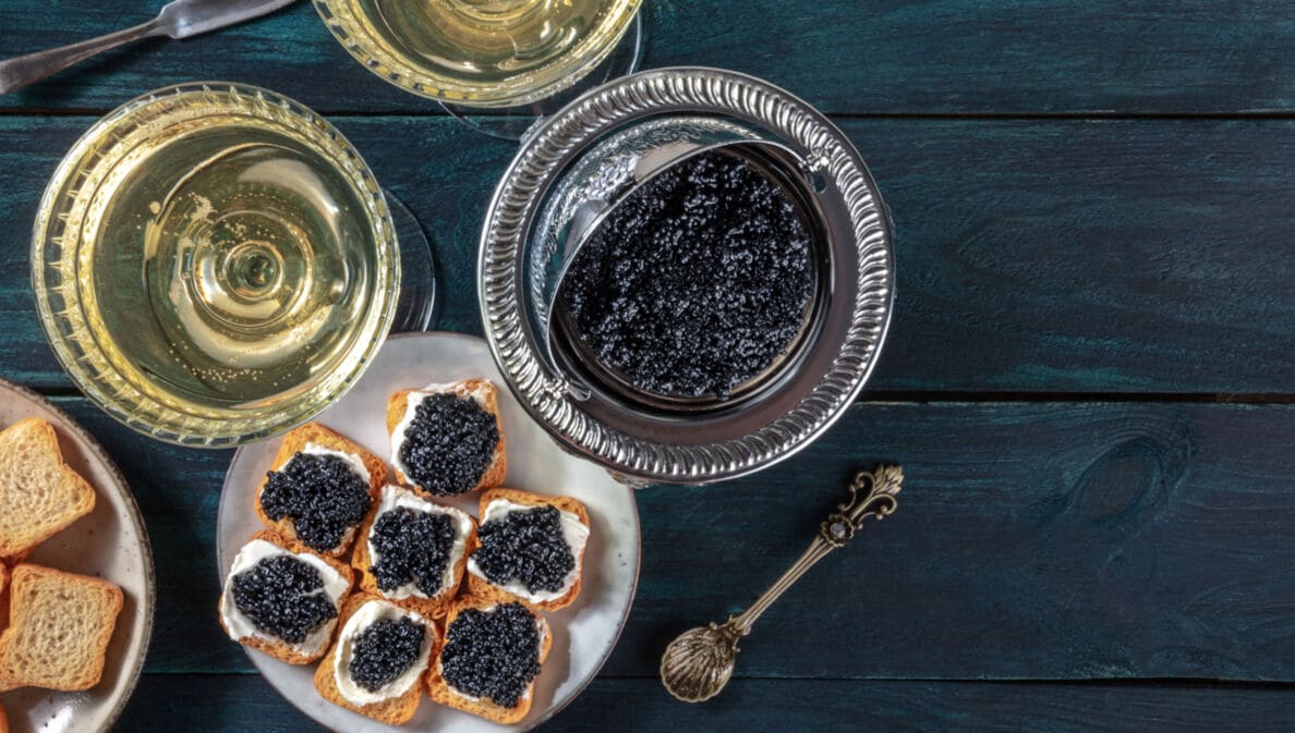 Sicht von oben auf eine Schüssel mit Kaviar und einen Teller mit Zwieback Creme und Kaviar