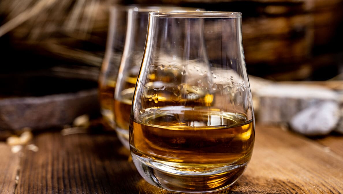 Eine Reihe von Whiskygläsern auf einem Holztisch