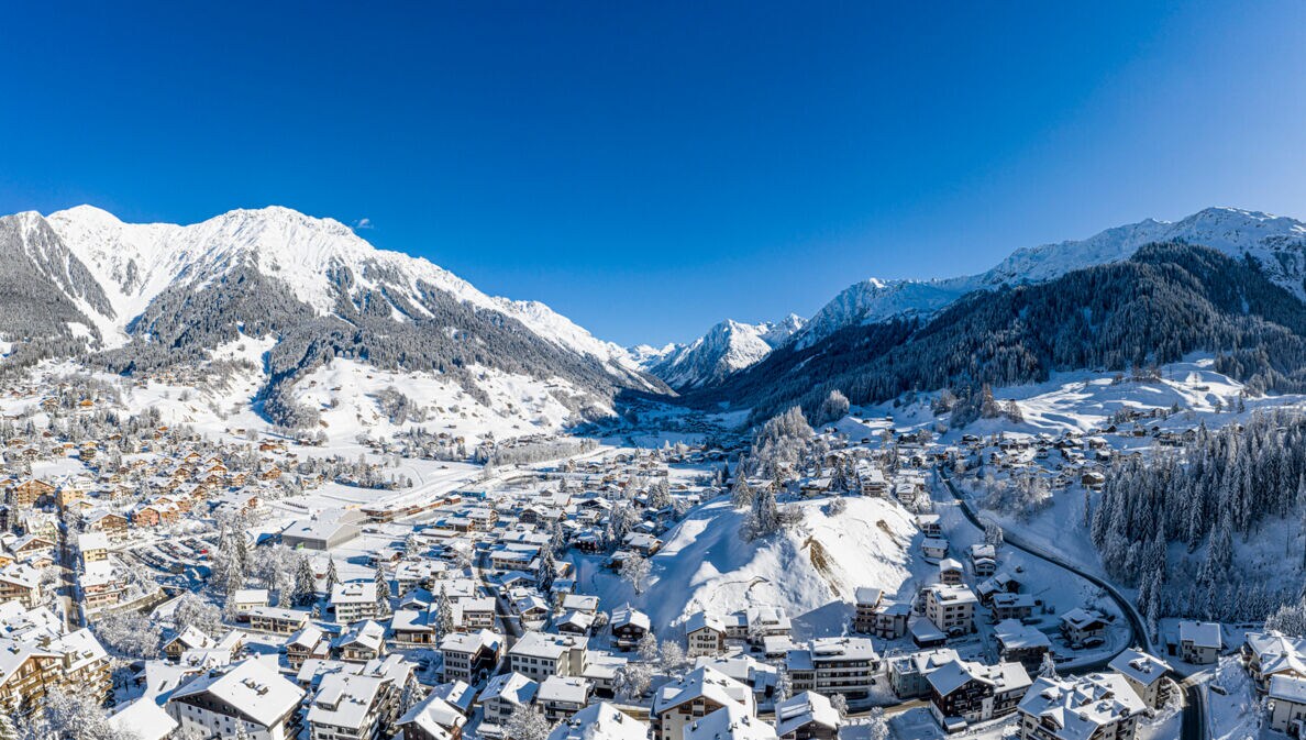 Blick auf die verschneite und im Tal liegende Ortschaft Klosters