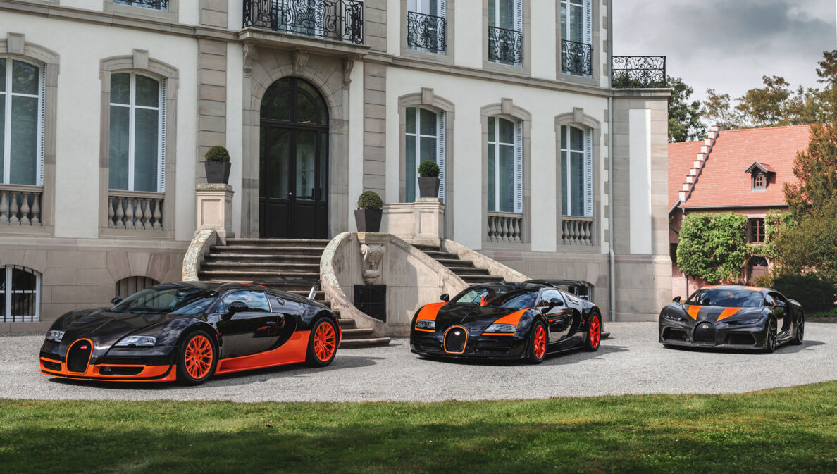 Drei Modelle von Bugatti vor einem Schloss