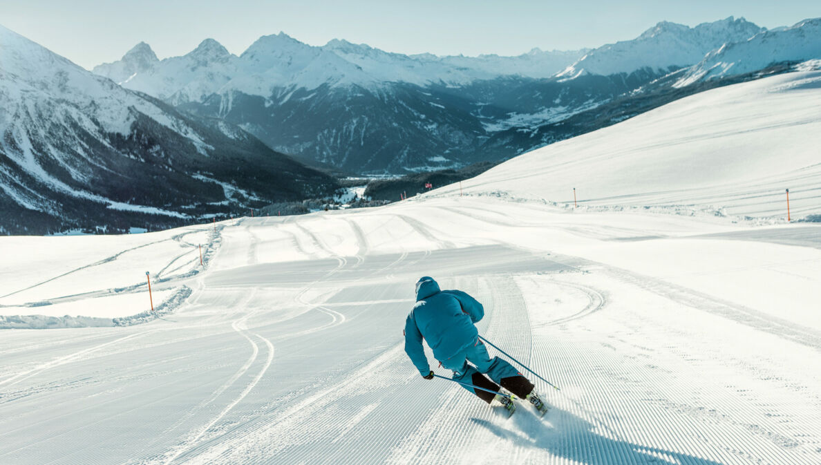 Eine Person fährt auf Skiern eine Abfahrt hinab.