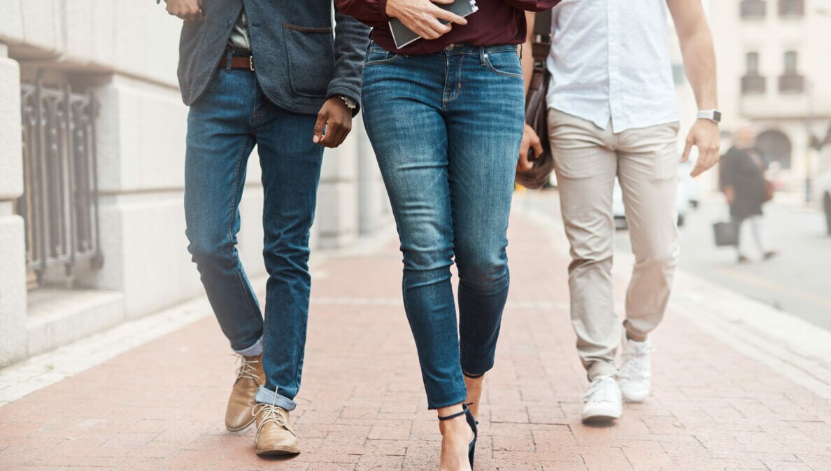 Drei Personen in Jeans gehen auf der Straße