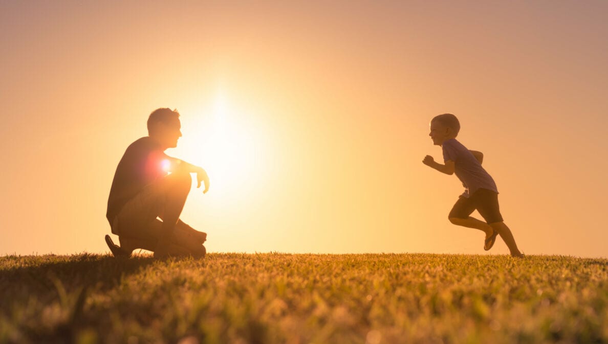 Ein Erwachsener und ein Kind gegen die Sonne fotografiert.