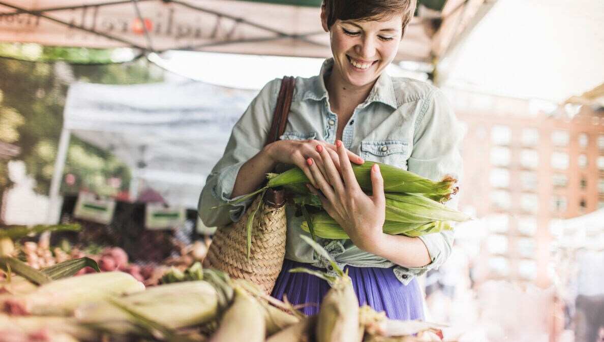 Eine Frau kauft frisches Gemüse auf dem Markt
