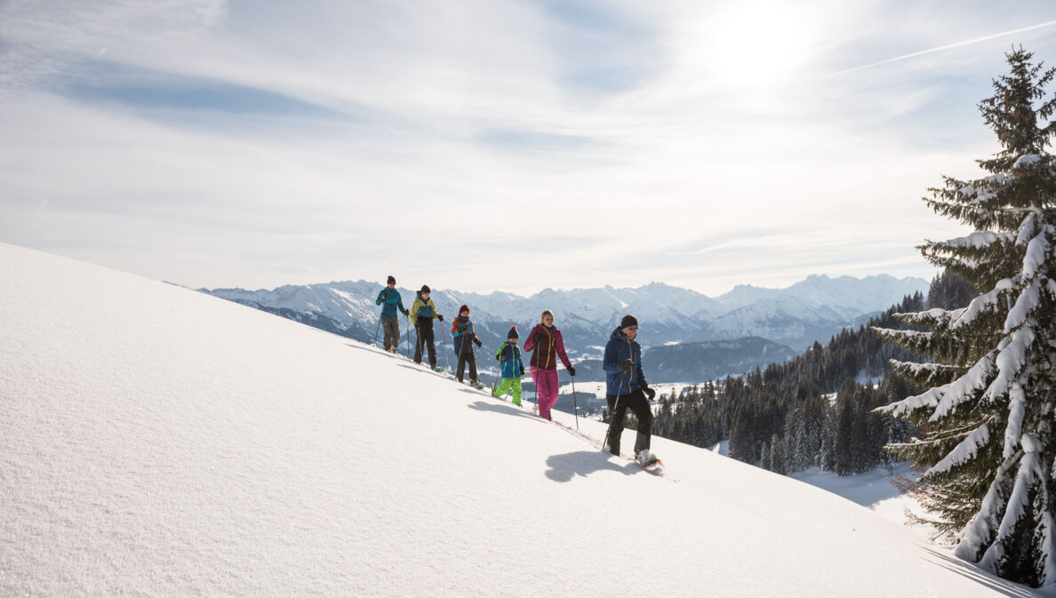Eine Gruppe Schneeschuhwanderer geht durch den Schnee