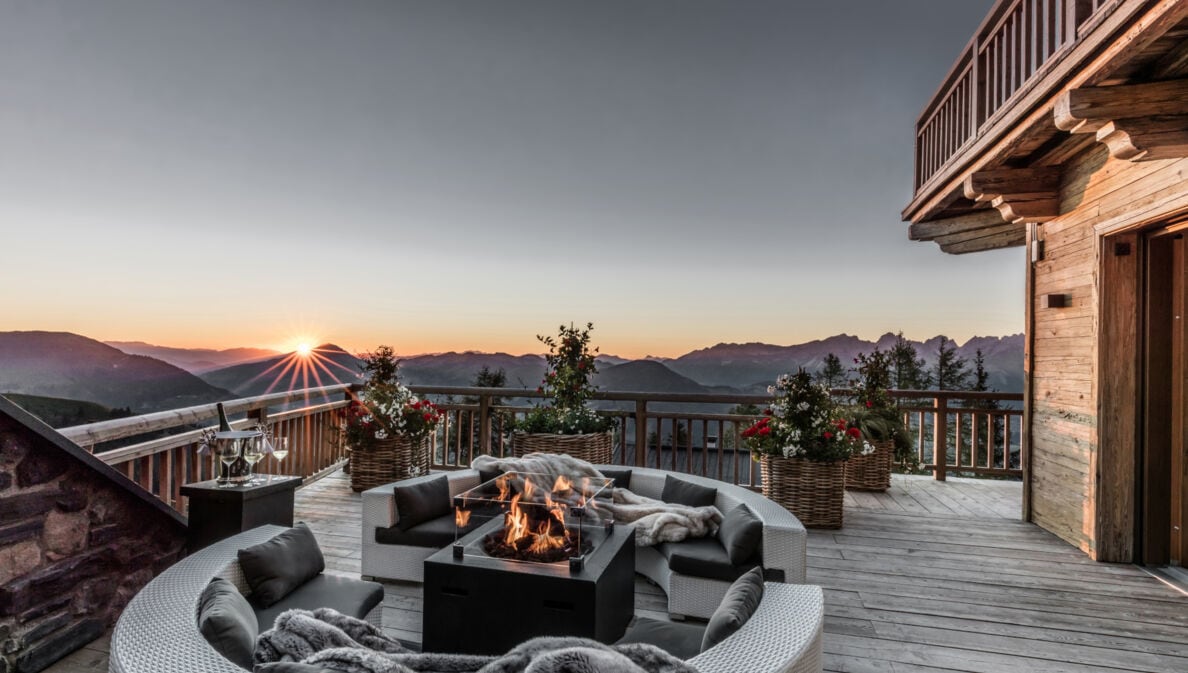 Eine Terrasse mit Feuerstelle und Blick über die Alpen