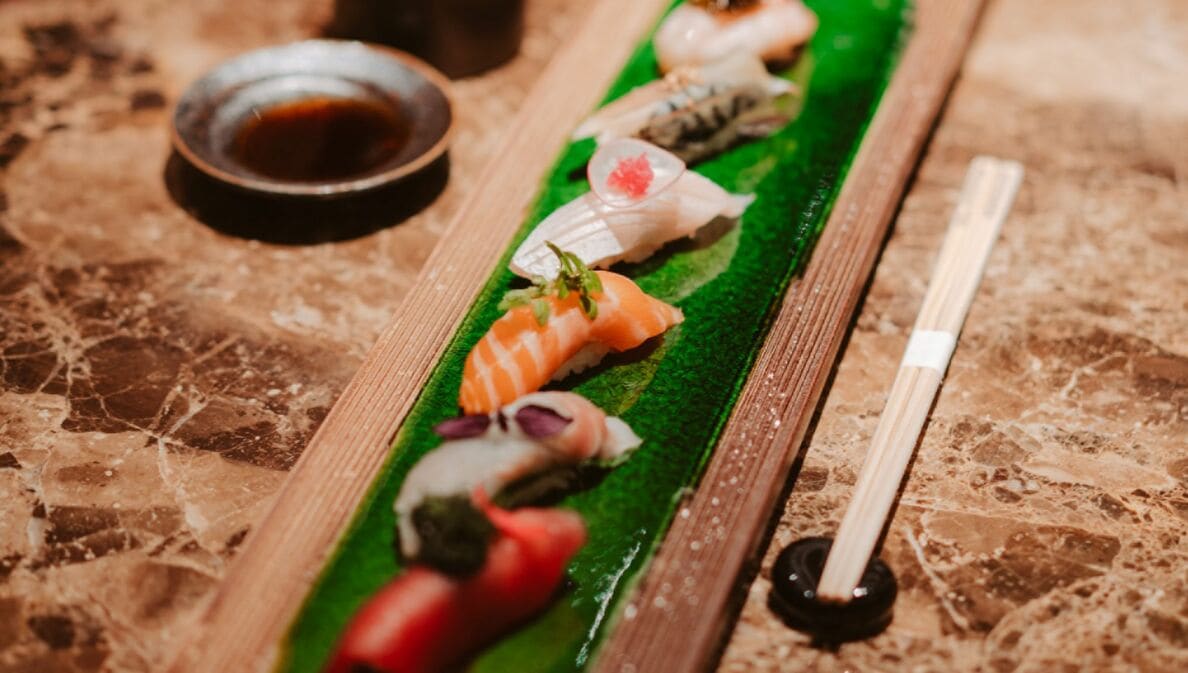 Sushi auf einer länglichen Platte angerichtet.