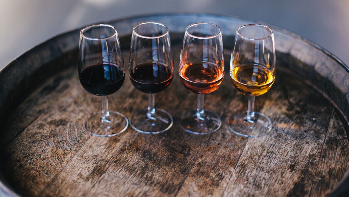 Vier Gläser Portwein auf einem Fass