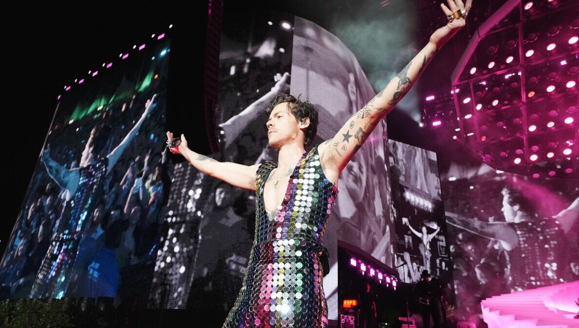 Sänger Harry Styles in einem glitzernden Paillettenanzug auf einer Bühne