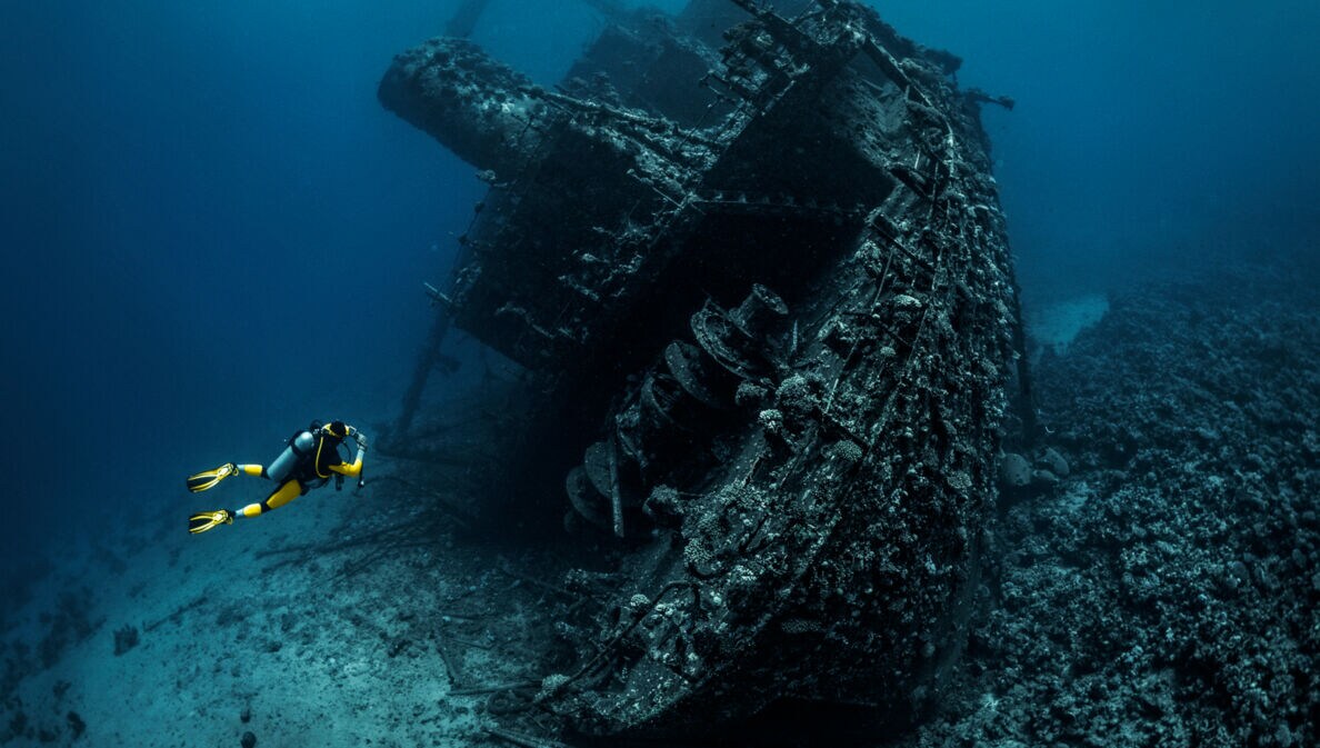 Taucher fotografiert das Wrack eines großen versunkenen Schiffes im Meer