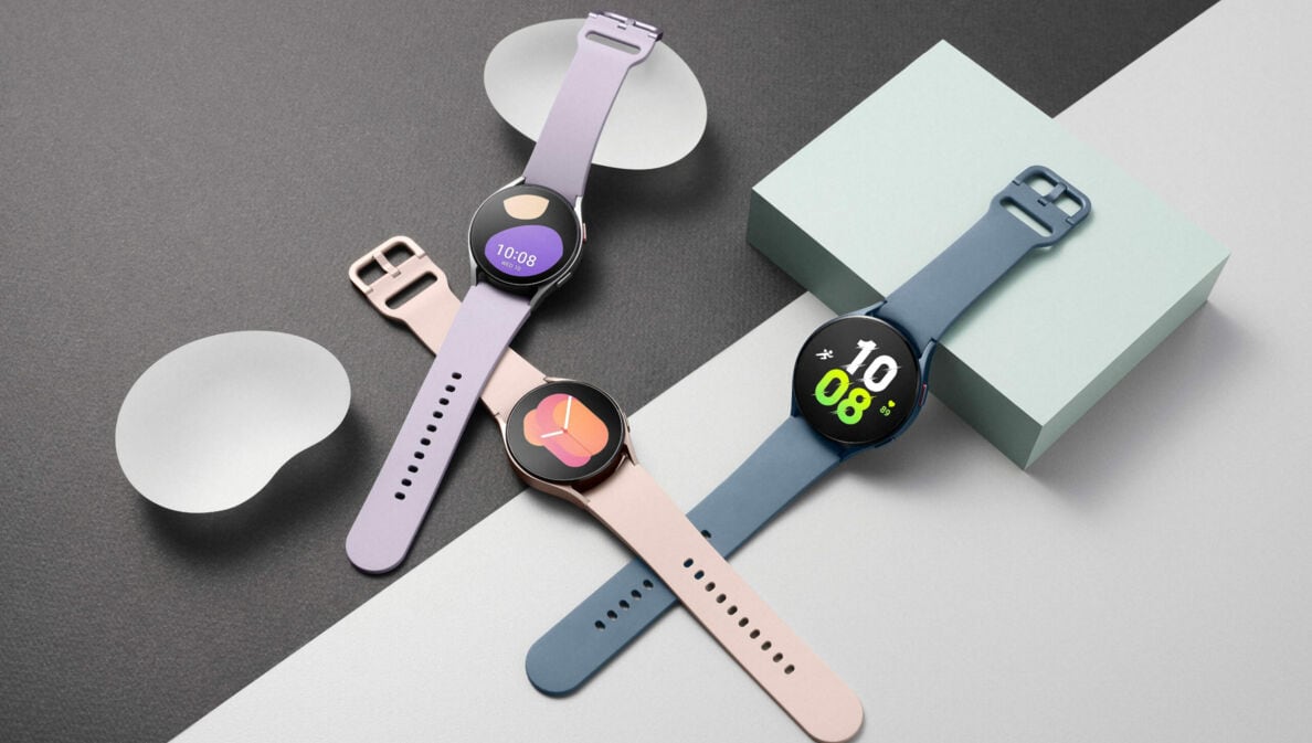 Drei verschiedenfarbige Uhren liegen auf einem grau-weißen Hintergrund