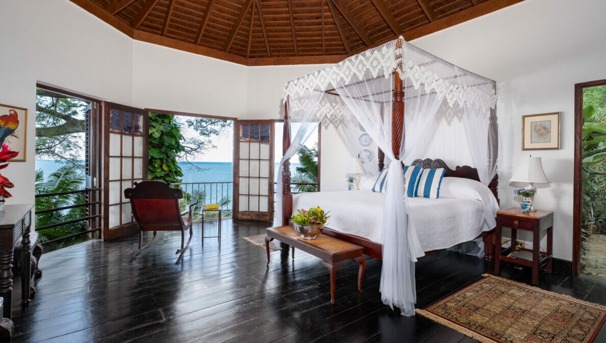Luxuriöse Hotelsuite im Kolonialstil mit Holzmöbeln und Meerblick
