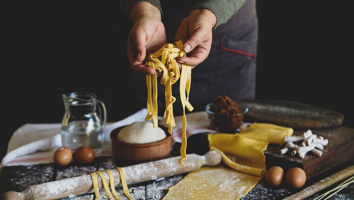 Eine Person hält selbstgemachte Pasta in die Kamera