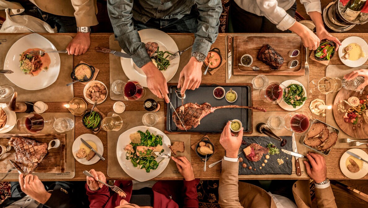 Top-Shot auf einen üppig gedeckten Tisch, an dem mehrere Personen sitzen und essen.
