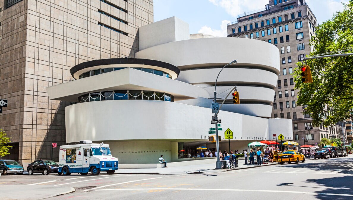 Blick auf das Guggenheim-Museum in New York, davor Autos und Menschen