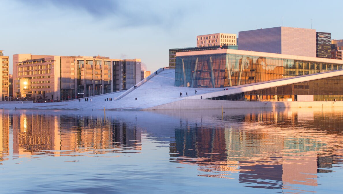 Weißes futuristisches Opernhaus mit Glasfassade am Wasser in Oslo