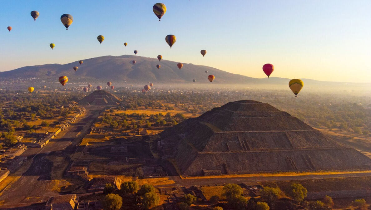 Heißluftballons über Pyramiden auf einer archäologischen Ruinenstätte bei Sonnenaufgang
