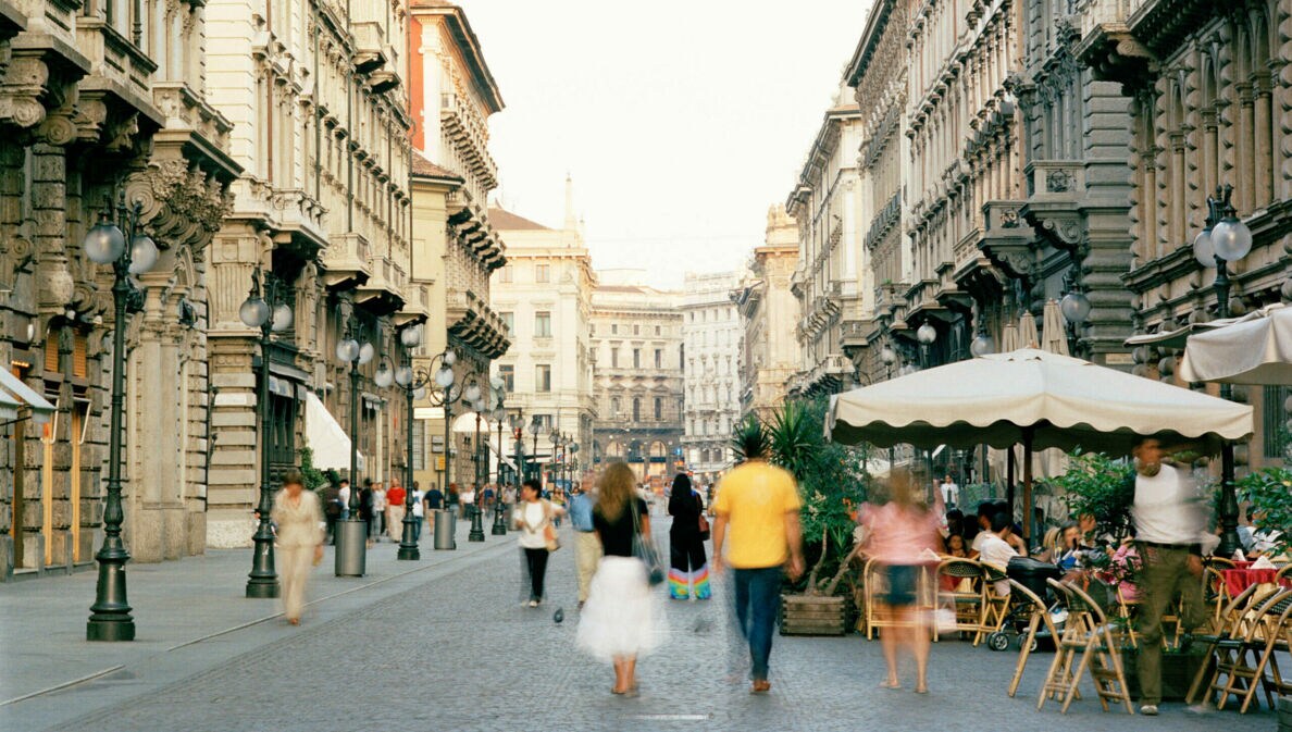Menschen auf einer belebten Straße mit Bars und Restaurants in Mailand