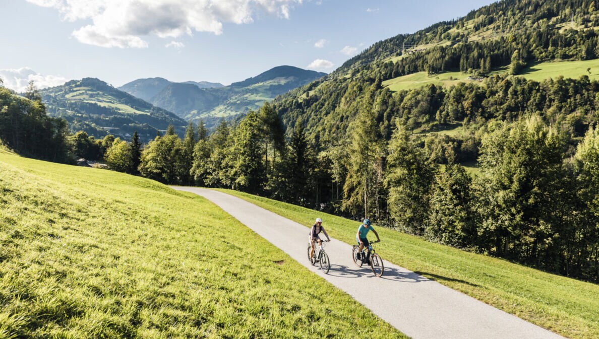 Zwei Menschen auf Rädern fahren über den Tauernradweg Alpe Adria