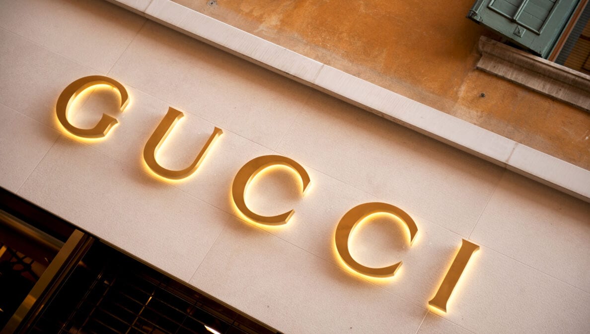 Das Logo von Gucci in Goldlettern an einer mediterranen Hausfassade