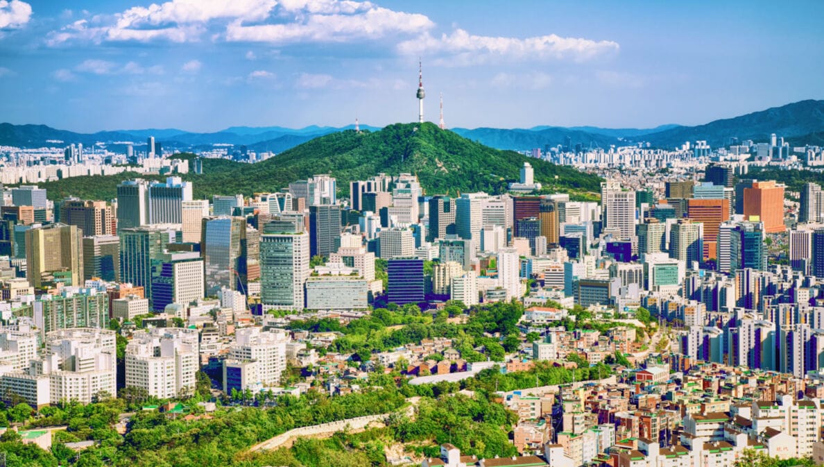 : Stadtpanorama von Seoul mit Hochhäusern, Stadtmauer und einem Fernsehturm auf einem Berg im Zentrum