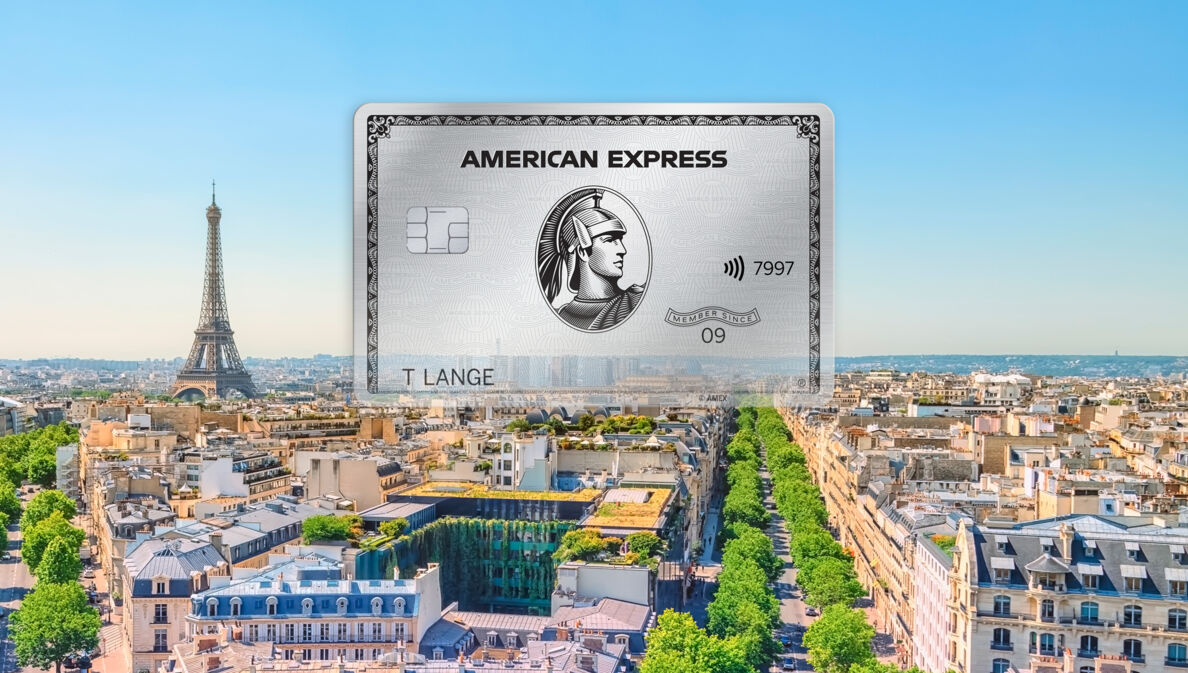 Fotocollage einer silbernen American Express Kreditkarte vor dem Stadtpanorama von Paris mit Eiffelturm.