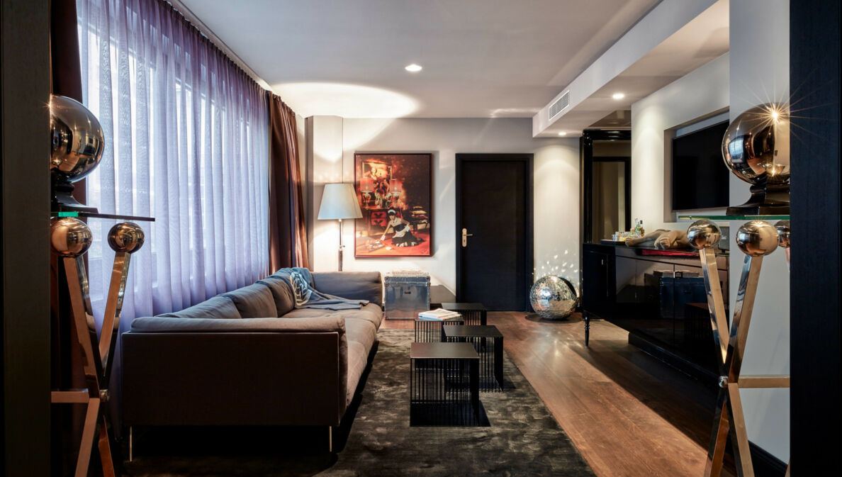 Moderne Hotelsuite mit Kunstwerken und silbernen Dekokugeln.