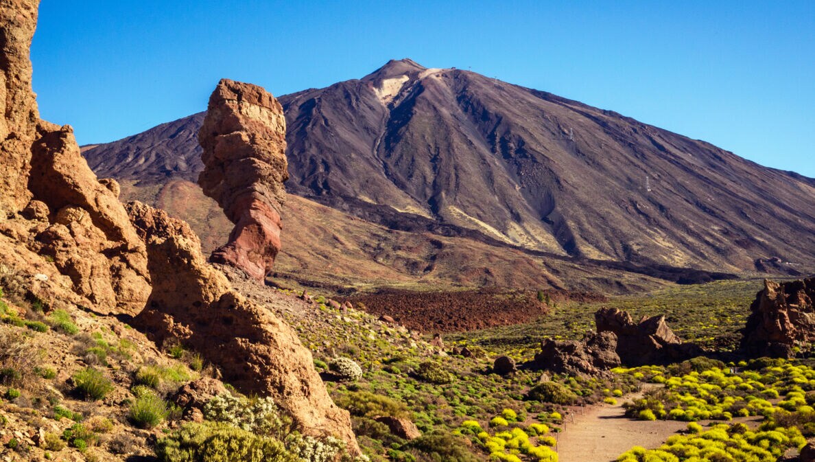 Eine Vulkanlandschaft mit Felsen und einem großen Berg im Hintergrund.