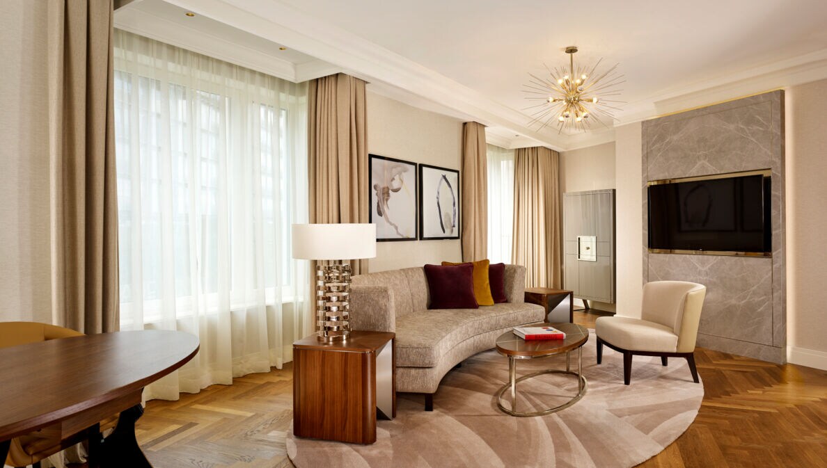 Stilvolle Hotelsuite mit Parkettboden und hellen Polstermöbeln.